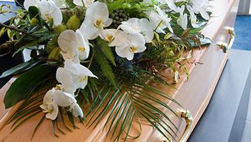 Flower arrangement lying on casket.