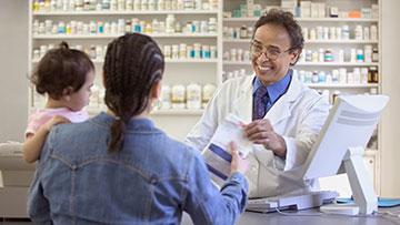 Pharmacist handing customer a prescription